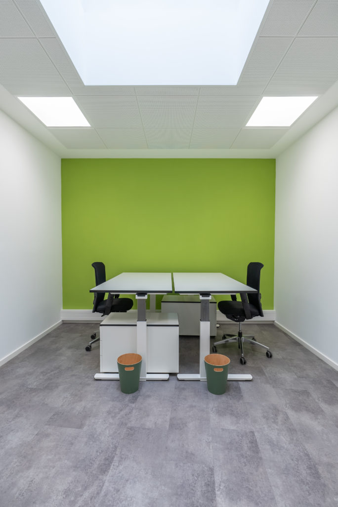 Team Office mit grüner Wand und zwei Schreibtischen